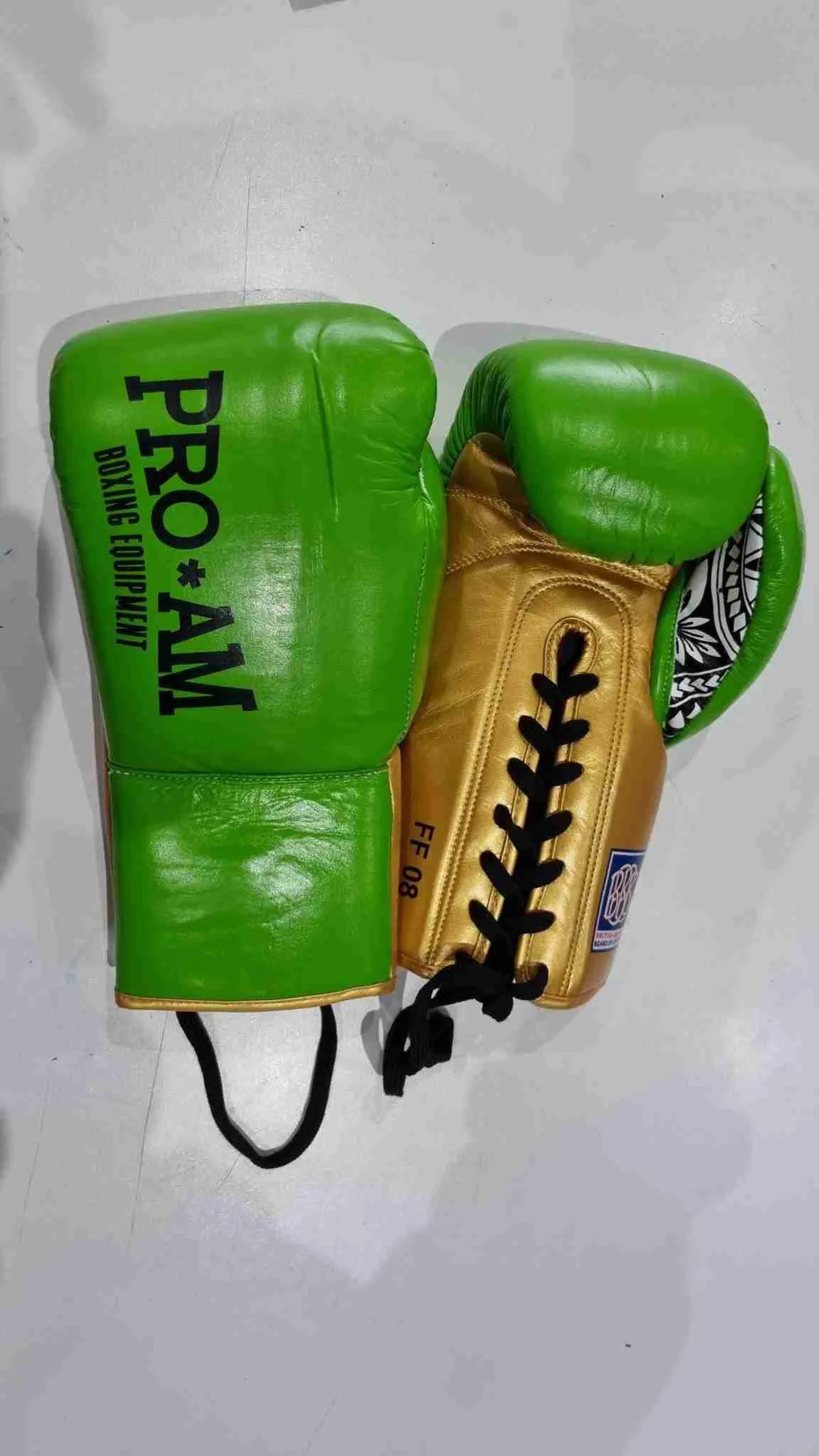 Pro-Am Undisputed professional boxing gloves by Proamboxinguk, BBBofC approved, showing black gloves with padded wrists and branding.